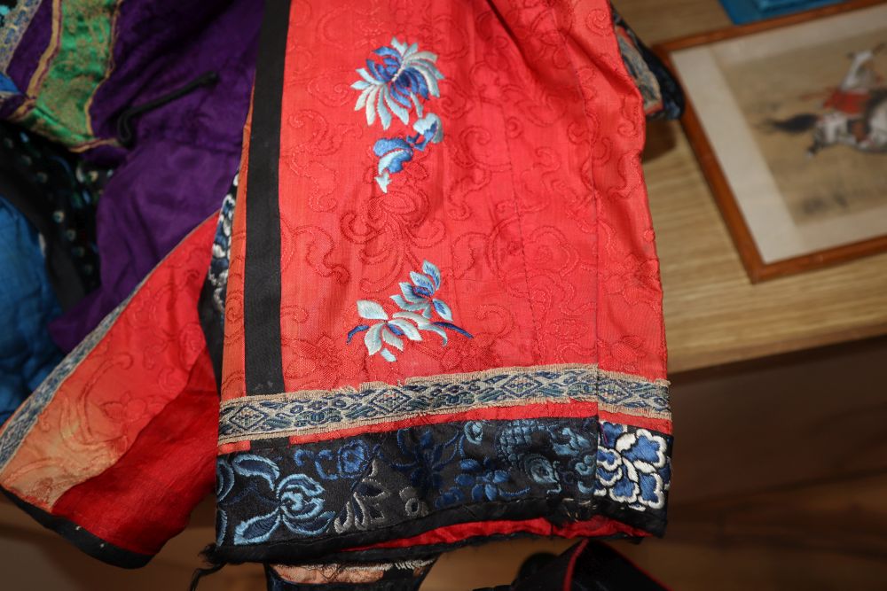 A Chinese purple silk quilted winter robe, decorated with multi-coloured embroidered edging, together with a red silk Chinese blue embr